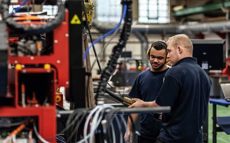 Esprit Automation Service Engineers performing specialized support and maintenance on a CNC Plasma Cutting Machine